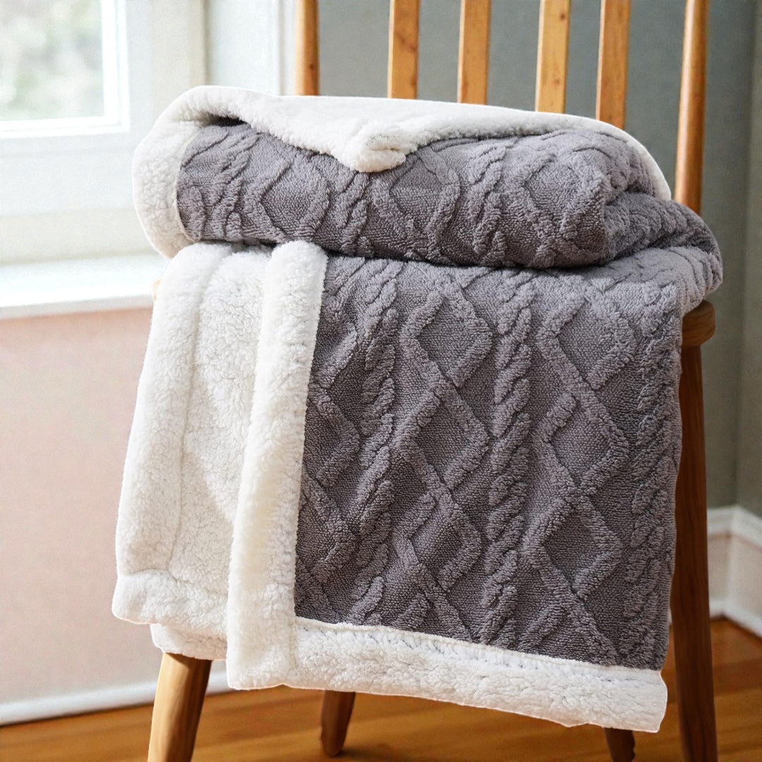 A sherpa fleece throw styled over the arm of a sofa